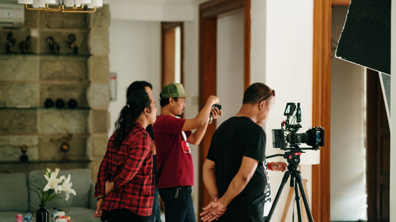 Equipo grabando una escena en interior con trípode y monitores